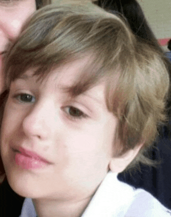 a close up of a child 's face with a woman 's face in the background