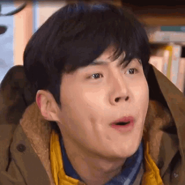 a close up of a man making a funny face while wearing a jacket .