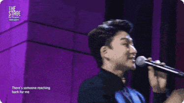 two men singing on stage with the words " there 's someone reaching back for me " on the bottom