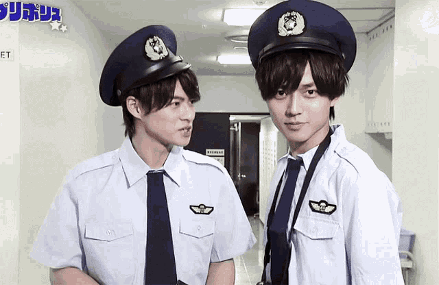 two police officers are standing next to each other in a hallway with a sign that says et on it