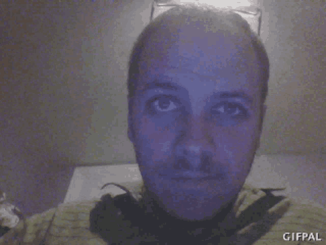 a close up of a man 's face with a gifpal watermark on the bottom right
