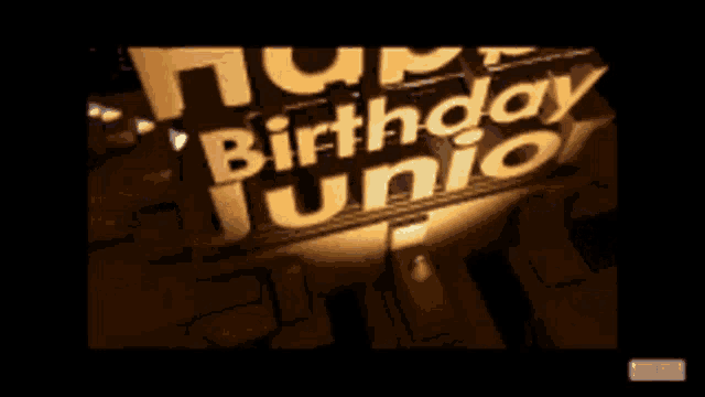 a sign that says happy birthday junior is lit up in the dark