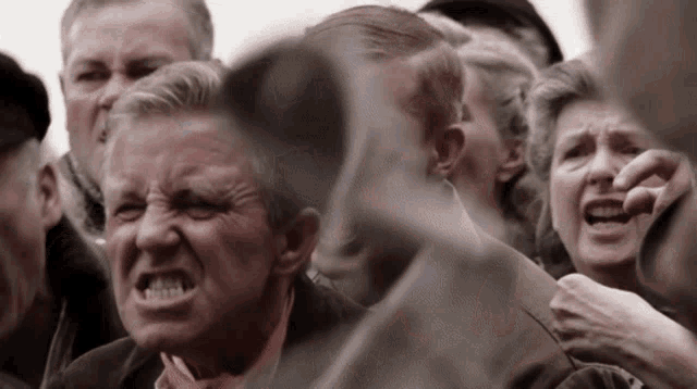 a man in a crowd making a funny face with his mouth open