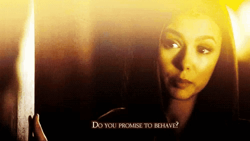a woman in a dark room with the words do you promise to behave