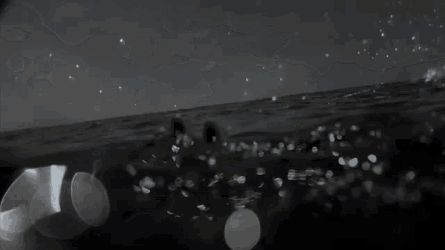 a black and white photo of a group of people swimming in the ocean .