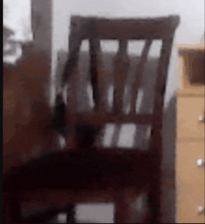 a wooden chair is sitting in a room next to a dresser .