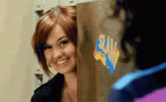 a woman is smiling behind a cardboard box with a sticker on it that says " sally "