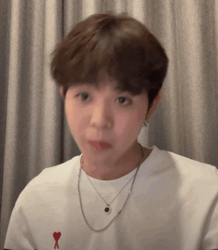 a young man wearing a white t-shirt with a red heart and the letter a on it