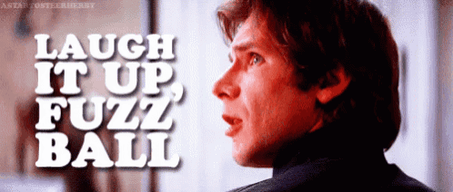 a close up of a man 's face with the words " laugh it up fuzz ball " above him