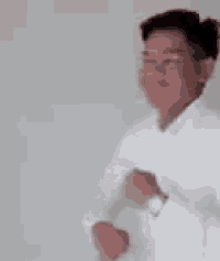 a man in a white shirt is dancing in a room with other people .