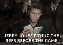 jerry jones is paying the refs before the game while sitting at a table .