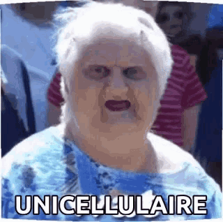 a woman in a blue shirt is making a funny face with the words unicellulare written on it .