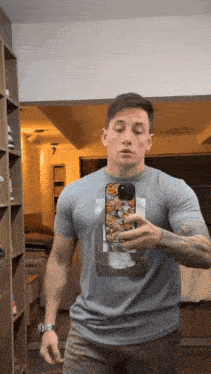 a man taking a picture of himself in a mirror with a case that has a picture of a cat on it