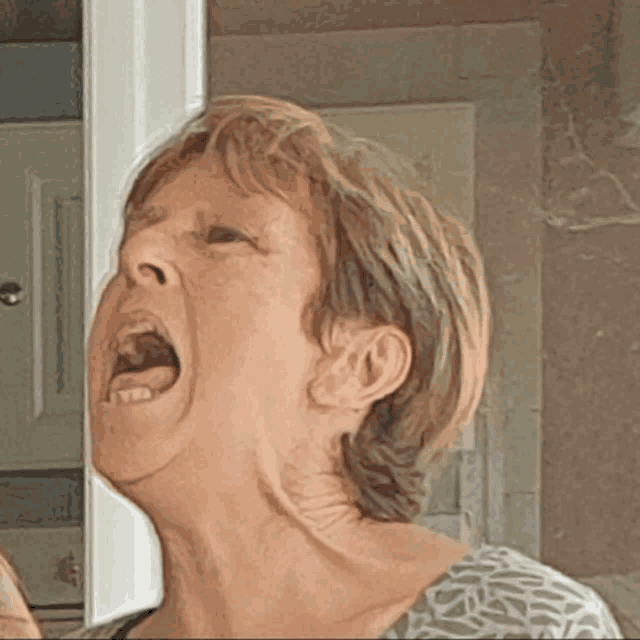 a woman with her mouth wide open looks at herself in the mirror