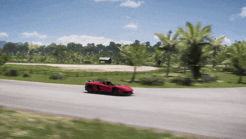 a red sports car is driving down a curvy road
