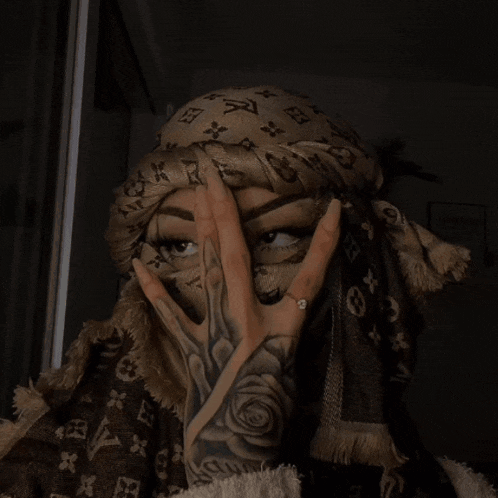 a woman wearing a scarf that says vuitton pa on it