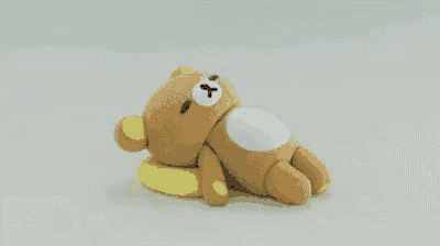 a stuffed teddy bear is laying on a yellow pillow .