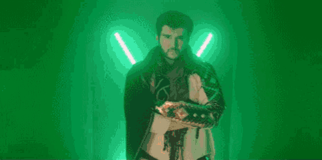a person in a hooded cape is standing in a dark room with purple lights .