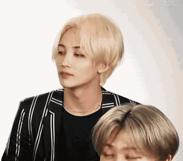 a man with blonde hair is standing next to another man with gray hair .