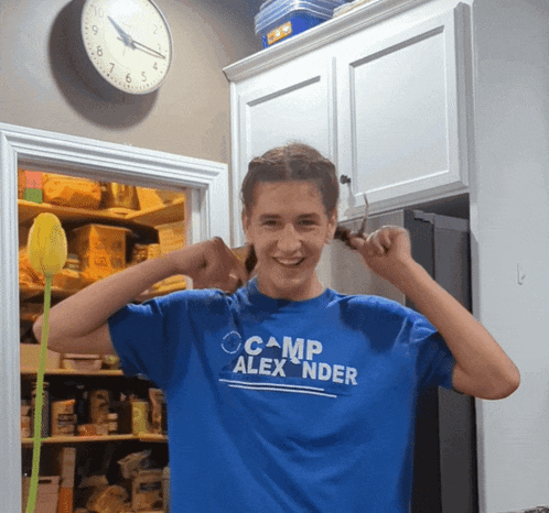 a young man wearing a blue shirt that says camp alex nder