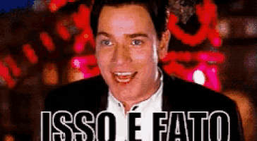 a man in a suit and white shirt is smiling with the words isso e fatto below him .