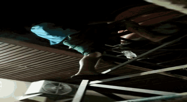 a fan is hanging from the ceiling next to a person 's feet