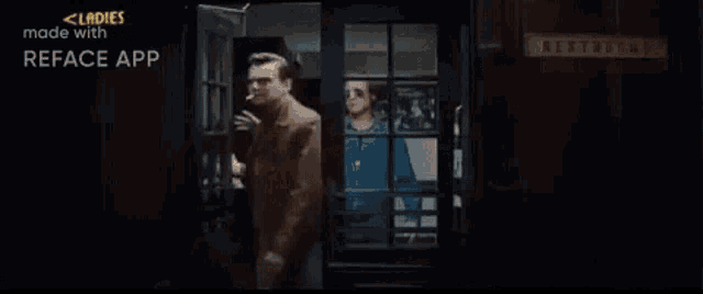 two men are standing next to each other in a dark room . one of the men is wearing sunglasses .