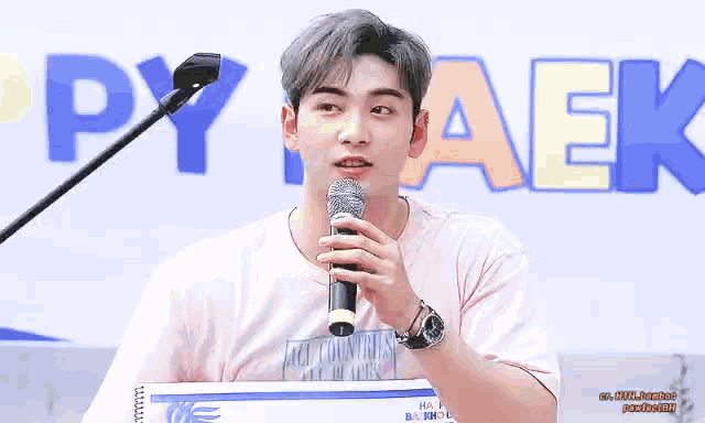 a young man is holding a microphone in his hand in front of a microphone .