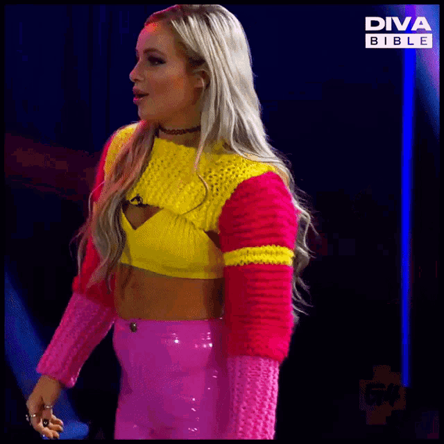 a woman in a colorful sweater and pink skirt is standing in front of a diva bible sign