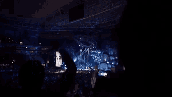 a crowd watching a concert with their hands in the air
