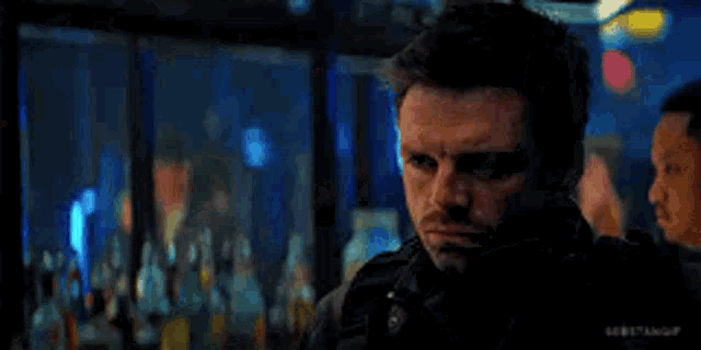 a man and a woman are looking into each other 's eyes in a dark room .