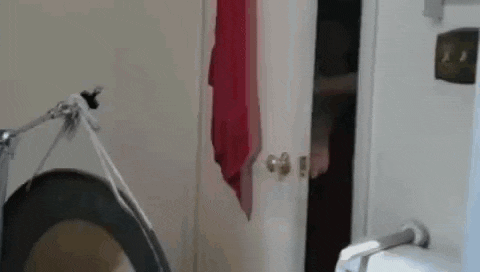 a person is standing in a bathroom next to a toilet and a door .
