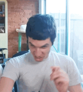 a man in a white shirt is making a face