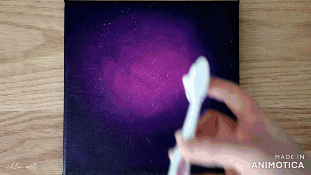 a person is holding a white spoon in front of a purple background that says " made in animatica "