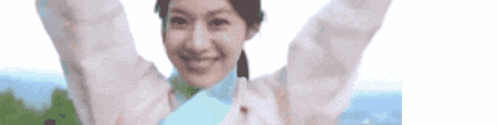 a woman with her arms in the air is smiling and looking at the camera