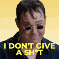 a man wearing sunglasses is making a funny face and saying `` i don t give a shit '' .