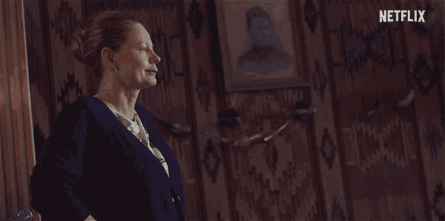 a woman says " you 're a coward " in front of a picture