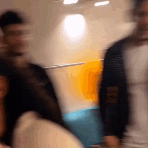 a blurry picture of people walking in front of a wall