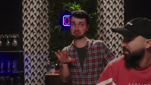 two men are standing in front of a neon sign that says o.