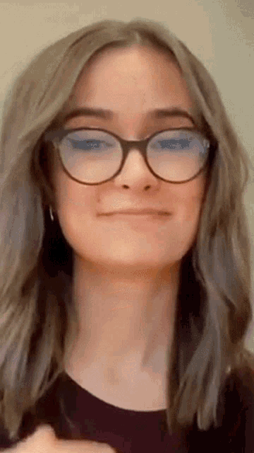 a close up of a woman wearing glasses and smiling .