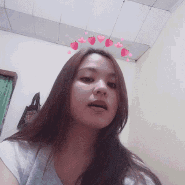 a girl with strawberries on her head looks at the camera