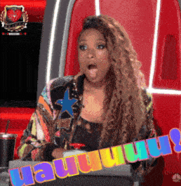 a woman with a surprised look on her face is holding a sign that says " uauuuu "