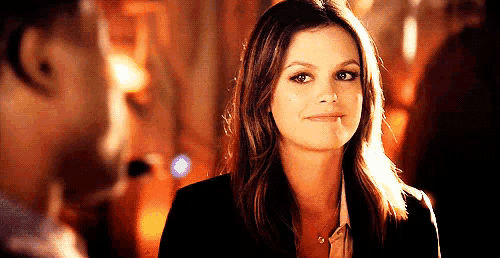a woman is smiling while looking at a man .