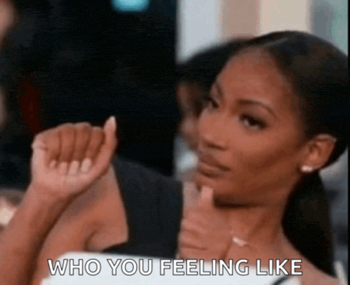 a woman is giving a thumbs up and saying `` who you feeling like '' while sitting at a table .