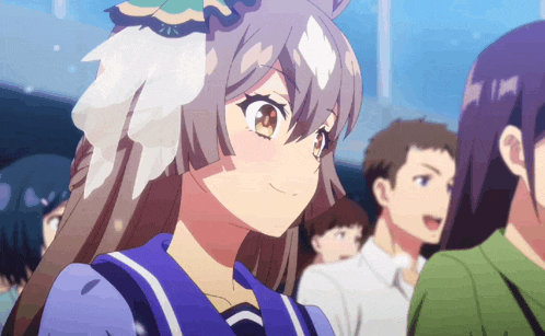 a girl with feathers on her head is smiling in a crowd of people