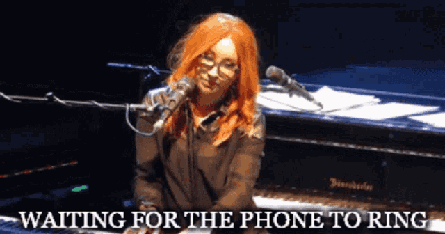 a woman singing into a microphone with the words waiting for the phone to ring above her