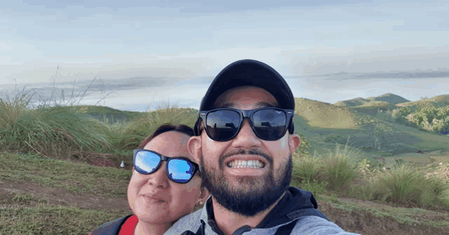 a man and a woman wearing sunglasses pose for a photo