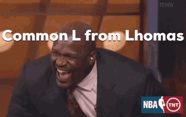 a man in a suit and tie is laughing with the words " common l from lhomas " behind him
