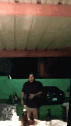 a man in a black shirt is standing in a garage