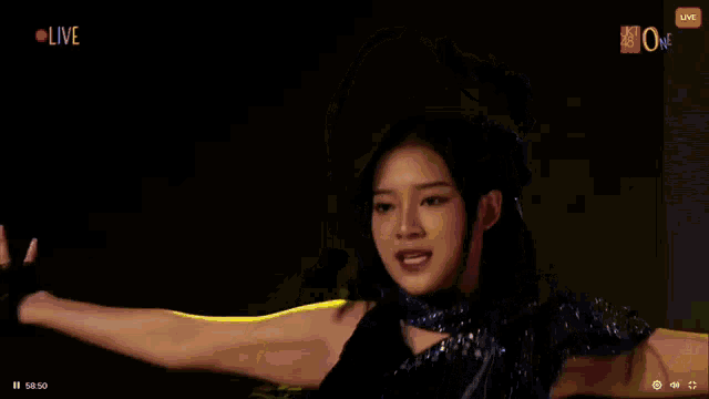 a girl is dancing in front of a live screen